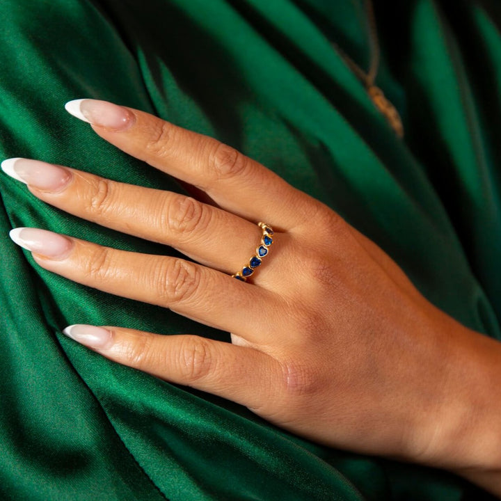 model wears 14k gold vermeil and blue cubic zirconia heart eternity ring